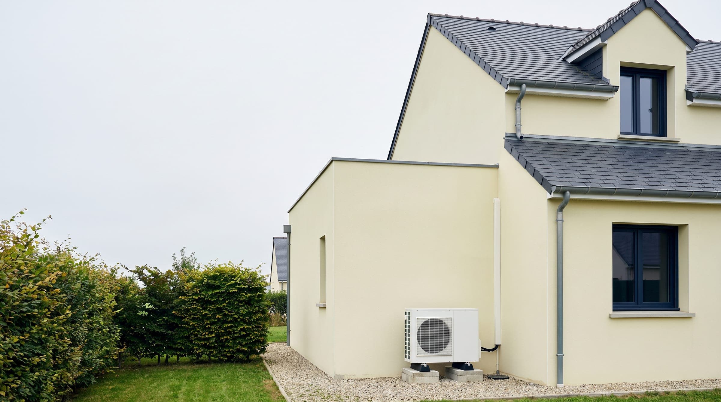 Maison contemporaine en Île-de-France avec une pompe à chaleur air/eau installée contre la façade, illustration générique