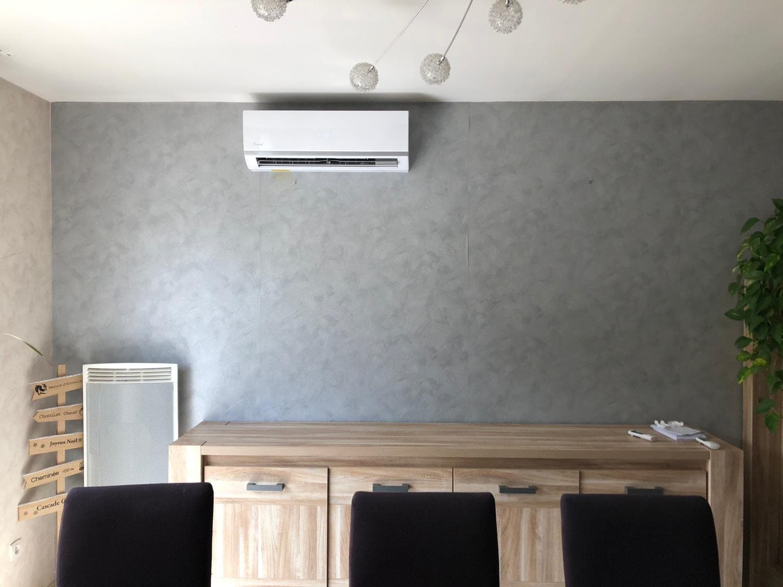 Unité intérieure murale de pompe à chaleur air/air installée au-dessus d’un buffet dans une pièce à vivre